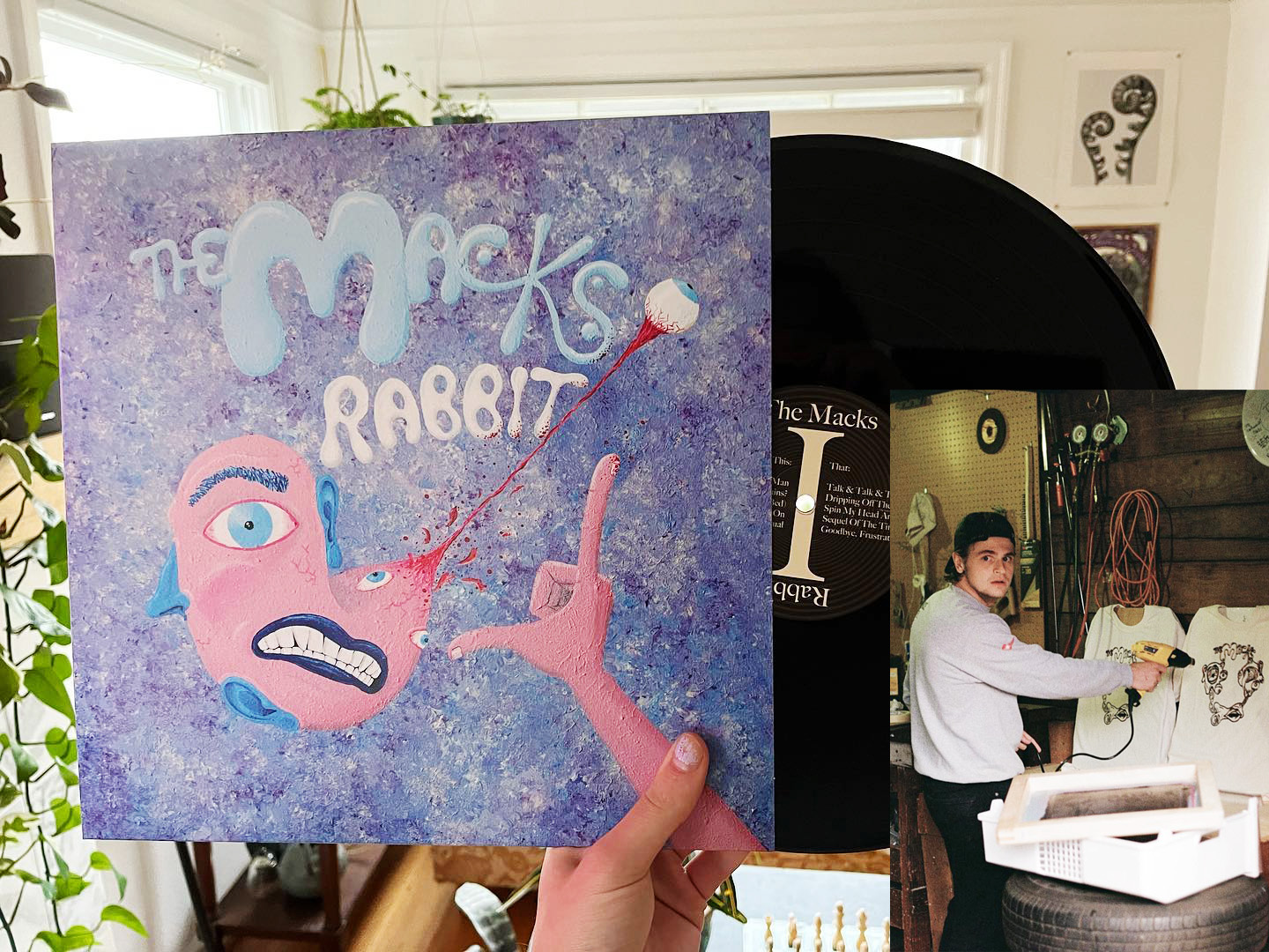 Hand holding up The Macks "Rabbit" vinyl with a small picture of Sam making logo shirts