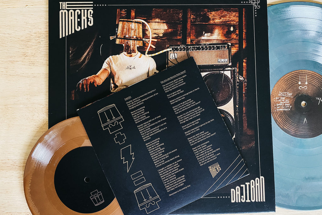 The Macks "Dajiban" album cover and green vinyl pictured with 7 inch hot brown wax vinyl that is part of the Dajiban Deluxe Edition on Bandcamp.