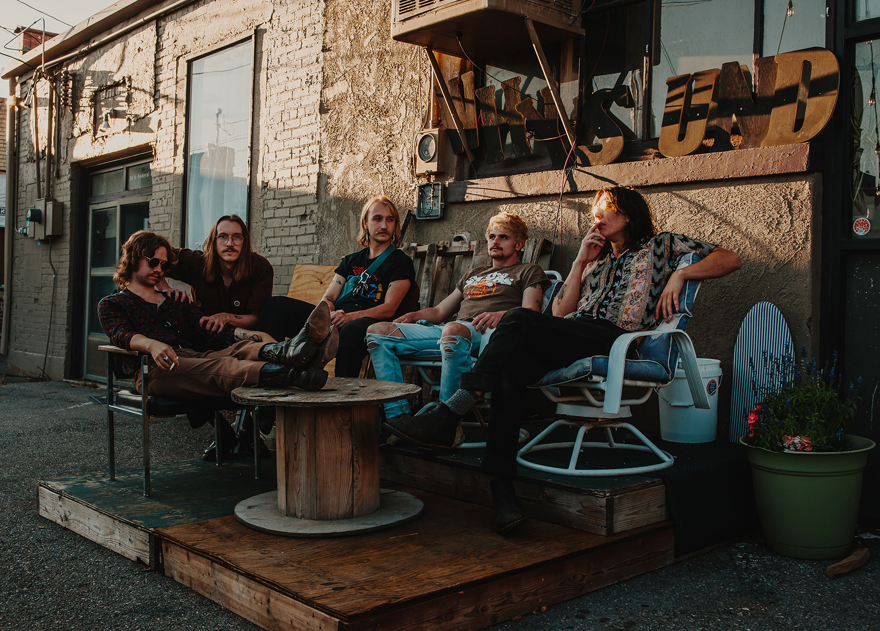 The Macks taking a break on tour in an Alley at sunset. Photo by Ian Enger.