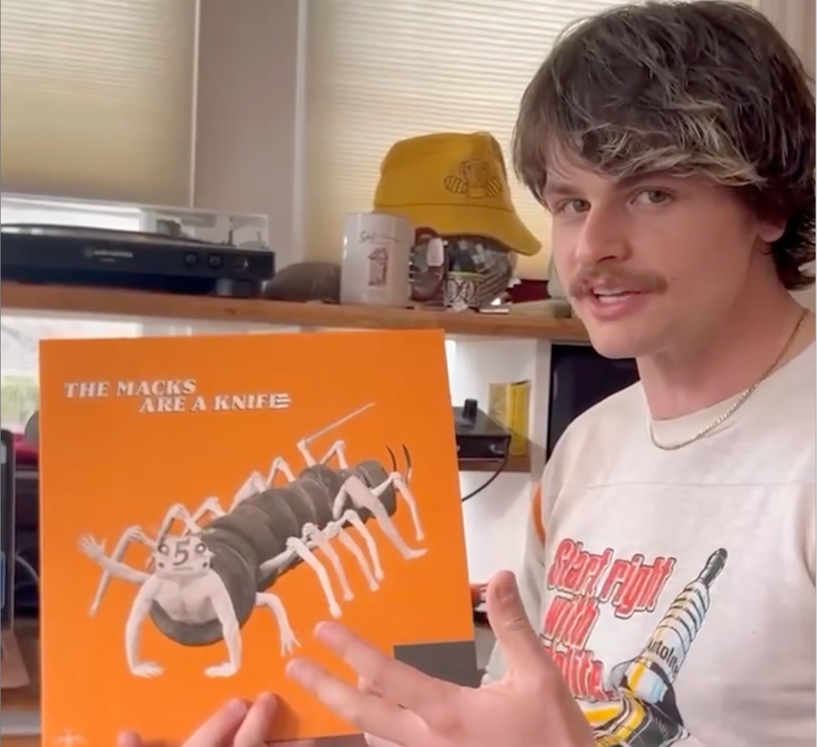 Sam Fulwiler holding the orange vinyl cover for The Macks are a Knife